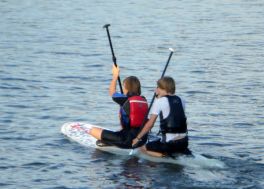 2 Kinder auf dem SUP sitzend